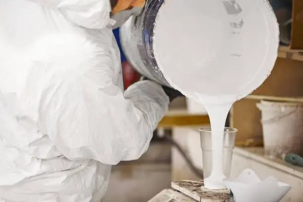 worker applying tin-catalyzed polyester resin coating